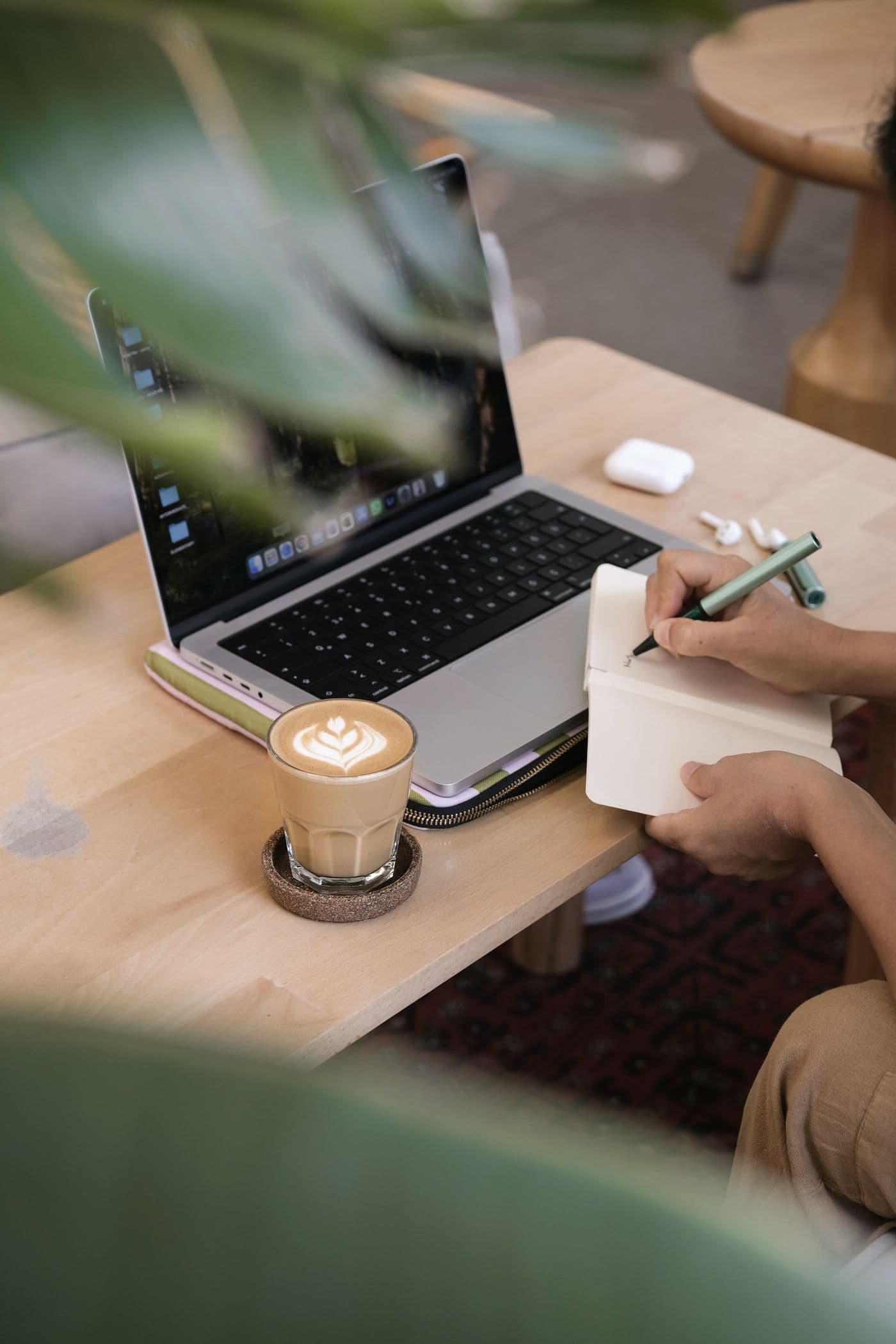 Owner taking notes next to a laptop and a cup of coffee